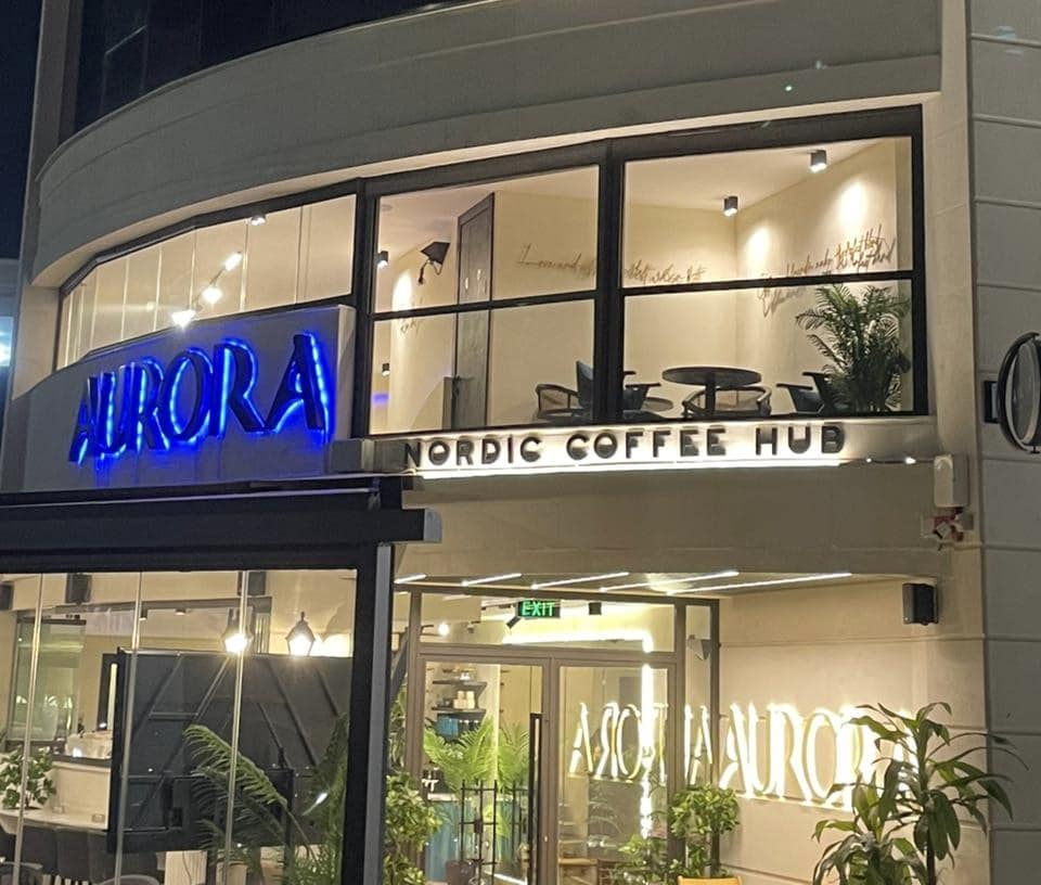 Aurora Coffee Hub storefront in Jordan reflecting Nordic precision and light roast philosophy with illuminated signage and cozy Scandinavian design.