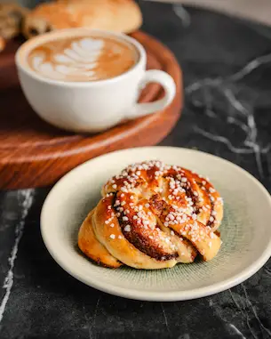 Authentic Nordic cinnamon bun topped with pearl sugar served at Aurora Coffee Hub.