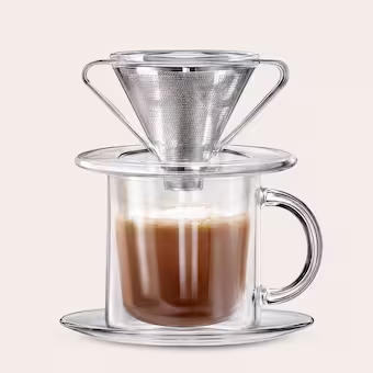 A stainless steel metal filter sitting over a clear glass cup illustrating traditional Vietnamese Phin coffee brewing.