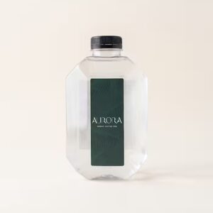 A geometric faceted clear water bottle with a black screw cap and dark green vertical Aurora Coffee Hub label on an off-white studio background.